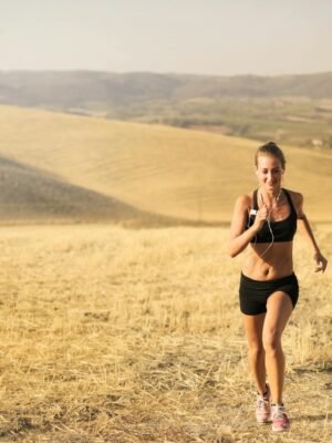 Happy young woman running in field