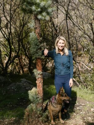 Woman in Blue Jacket Standing Beside Brown and Black German Shepherd