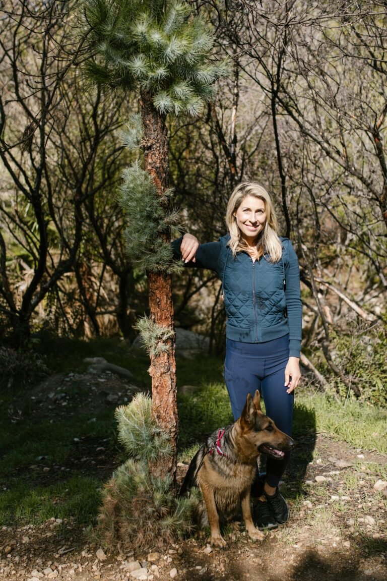 Woman in Blue Jacket Standing Beside Brown and Black German Shepherd