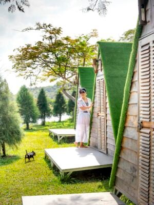 Woman standing on porch of bungalow in camping